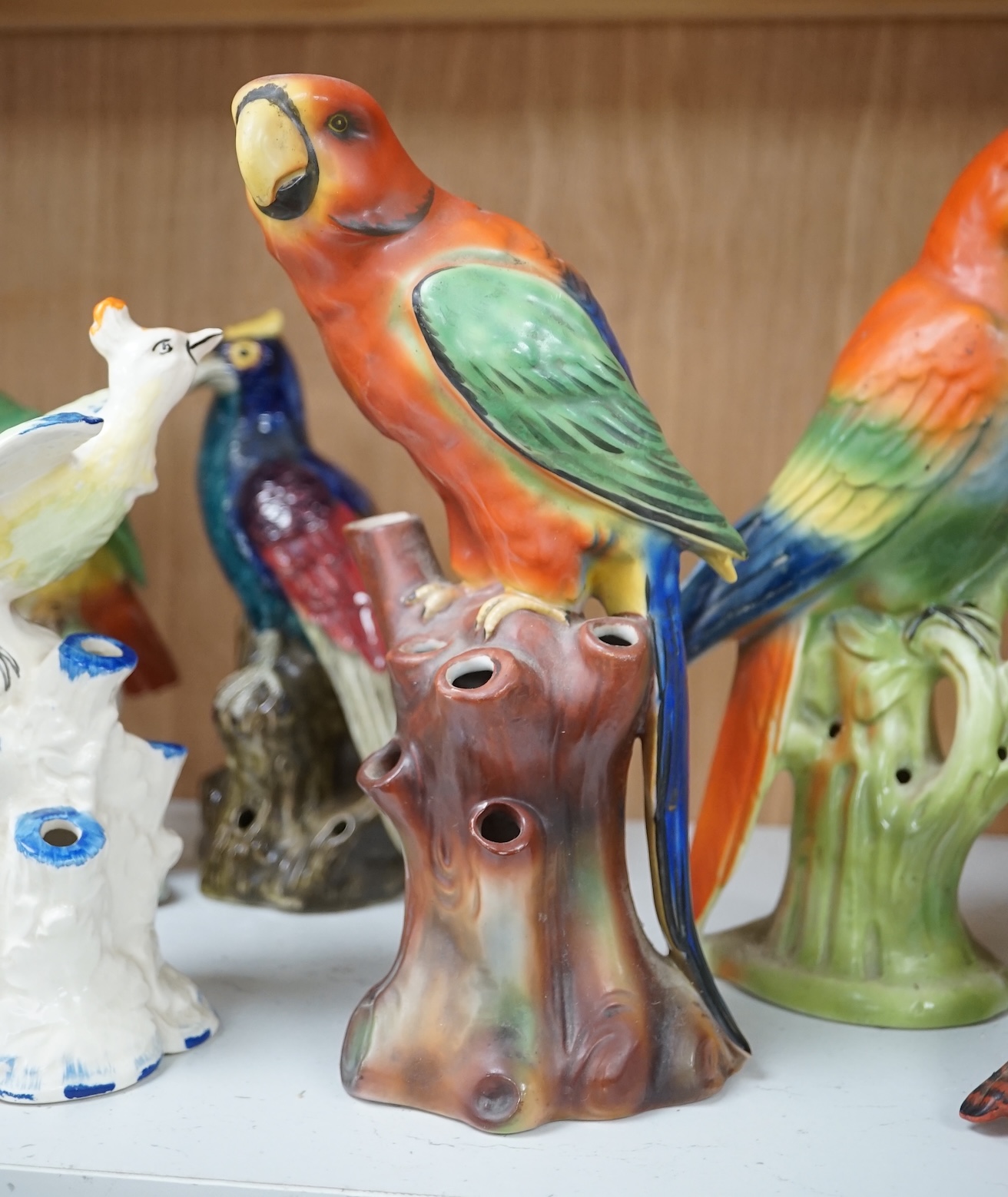 A group of twelve ceramic parrots including one by S Hancock & Sons, largest 24cm high. Condition - mostly good